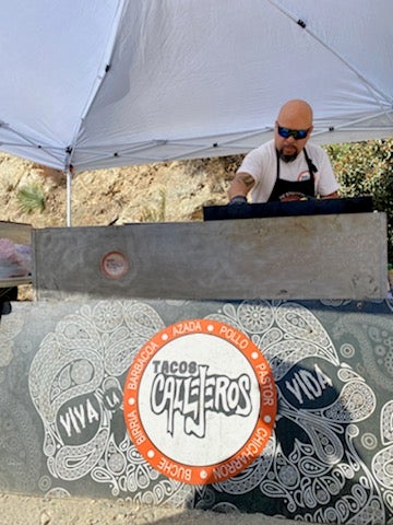 Cortes behind a Tacos Callejeros grill.