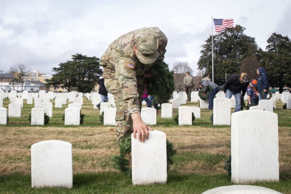 A soldier pays his respects at a cemetery