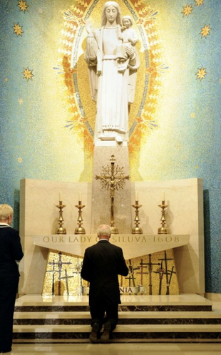 Biden kneeling at a chapel in September, 2011, will attend the National Prayer Breakfast virtually.