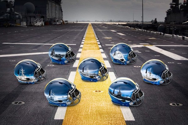 Midshipmen playing the Army-Navy game with the fleet painted on their helmets