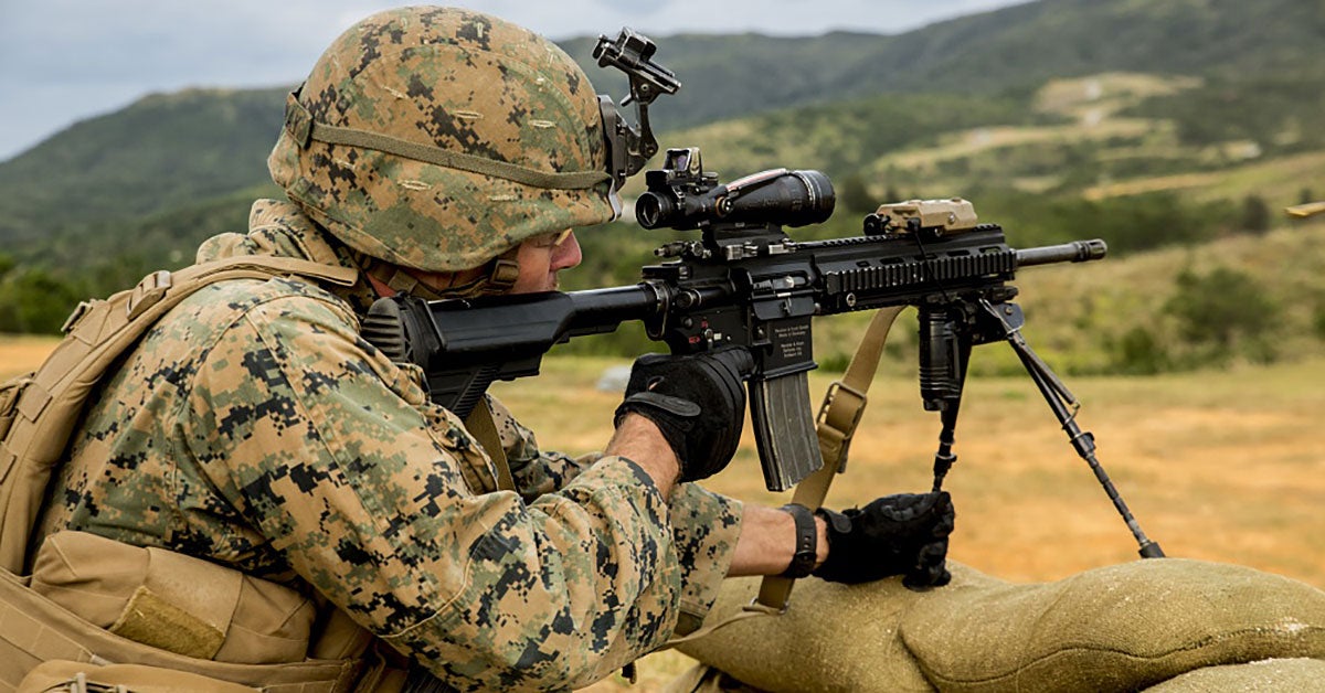 A soldier firing an M27