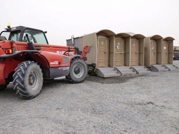 A truck moves five port-a-potties