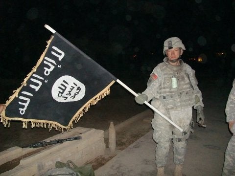 These 13 photos of US troops with enemy flags show some traditions never die