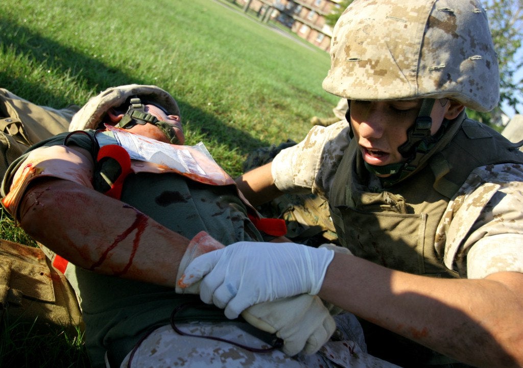 A corpsman assessing an injury during a training session