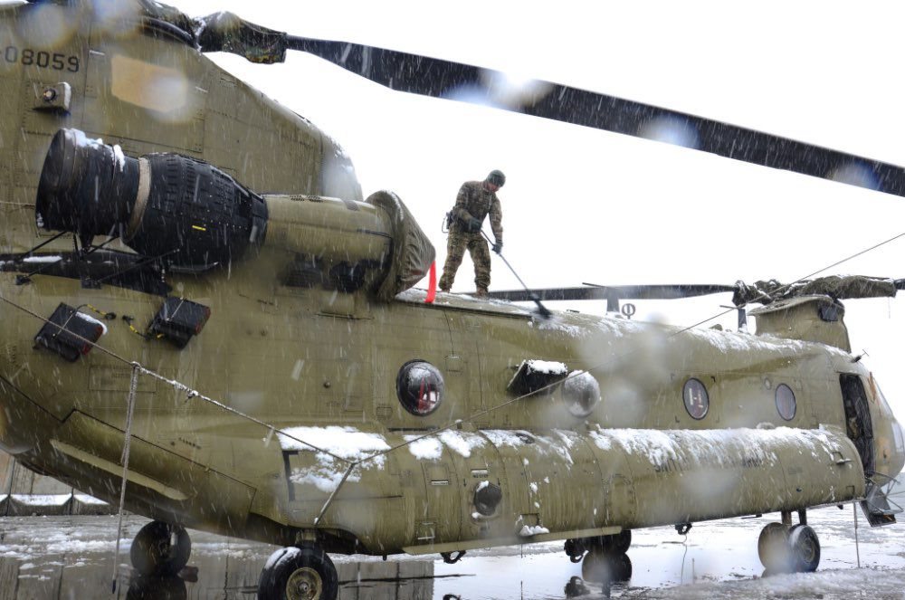 Cold soldier clearing snow off a Chinook