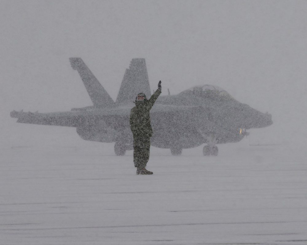 Cold sailor directing air traffic in the snow