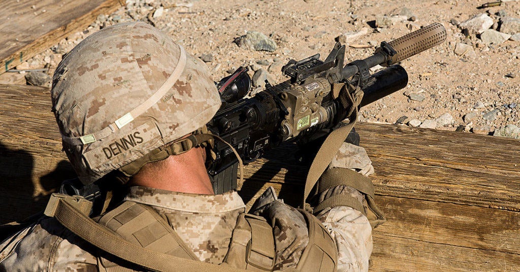A Marine using a rifle with a silencer