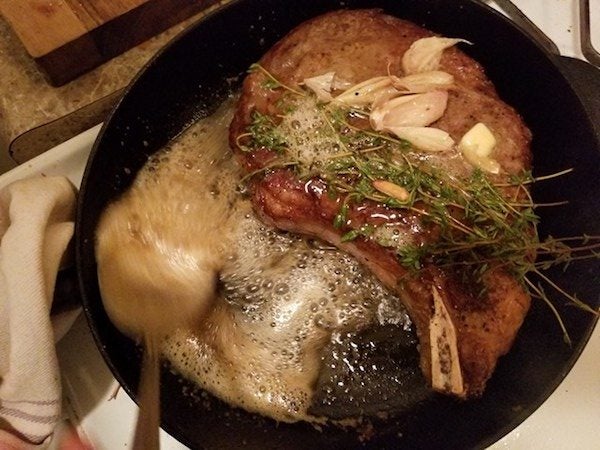 A steak cooking in a pan