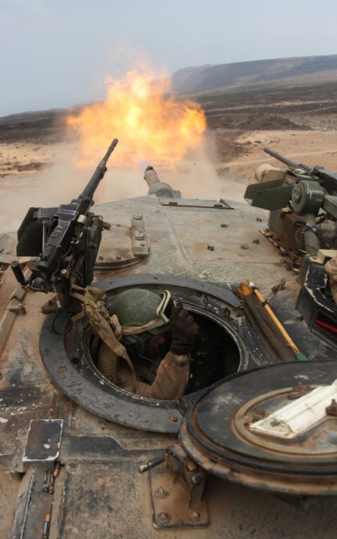 Lance Cpl. William Laffoon, tank crew man with Tank platoon Alpha Company, Battalion Landing Team 1st Battalion, 9th Marine Regiment, 24th Marine Expeditionary Unit, braces himself after firing a 120mm round from a M1A1 Abrams battle tank during a live-fire range in Djibouti. (U.S. Marine Corps photo by Sgt. Alex C. Sauceda)