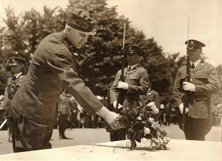 Soldier placing flowers on a tomb