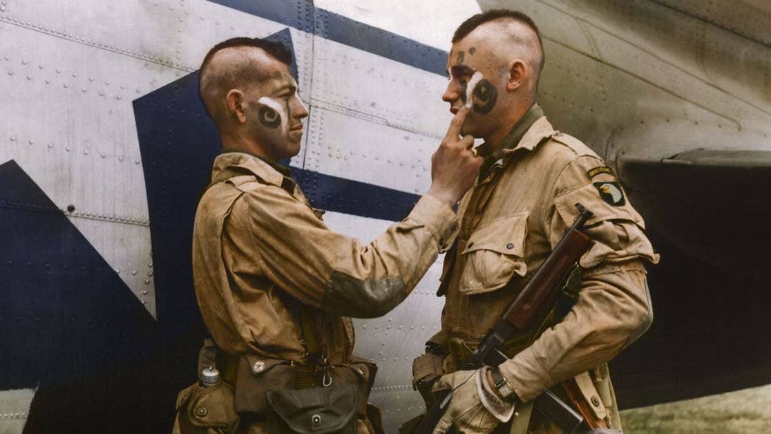 Original Caption: Pvt. Clarence C. Ware, 438 W. 15th St., San Pedro, Calif., gives a last second touch to Pvt. Charles R. Plaudo, 210 N. James, Minneapolis, Minn., make-up patterned after the American Indians. Somewhere in England. (Wikimedia Commons)