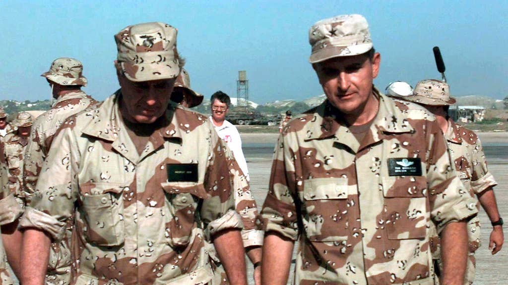 US President George Bush, left and wearing a desert camouflage BDU shirt and cap, walks toward the camera with US Air Force BGEN Thomas Mikolajcik, Commander AFFOR, right.  Other members of the Air Force as well as the media are seen in the background.  The President was visiting Somalia to witness first hand the efforts of Task Force Somalia that is in direct support of Operation Restore Hope.