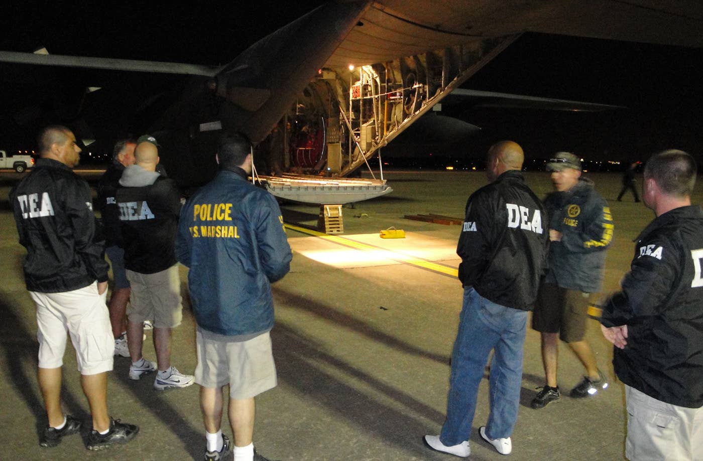 Agents from the U.S. Department of Justice's Drug Enforcement Agency, U.S. Marshall's office and the DOJ's Criminal Division await the offloading of several pallets of seized gold, silver and jewels April 9 in Austin, Texas. The seize assets were part of a joint Panama-U.S. investigation into an international drug money laundering scheme in the Central American country. The Air Force Reserve's 302nd Airlift Wing was charged with flying the seized precious metals and jewels back to the United States from Panama for further processing by Department of Justice agencies. (Courtesy photo/Drug Enforcement Agency)
