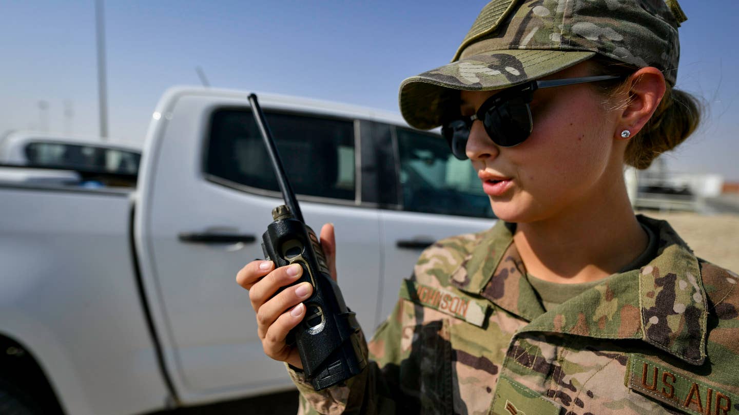 U.S. Air Force Airman 1st Class Page Johnson, 386th Civil Engineering Squadron force protection escort, radios dispatch at Ali Al Salem Air Base, Kuwait, Sept. 4, 2019. The force protection flight provides a security buffer between other country nationals such as contractors, their employees and the general base population. Airmen assist and escort OCNs during their duty day, help minimize potential data collection, and ensure departure of vehicles and personnel once their services are completed for the day. (U.S. Air Force photo by Staff Sgt. Mozer O. Da Cunha)