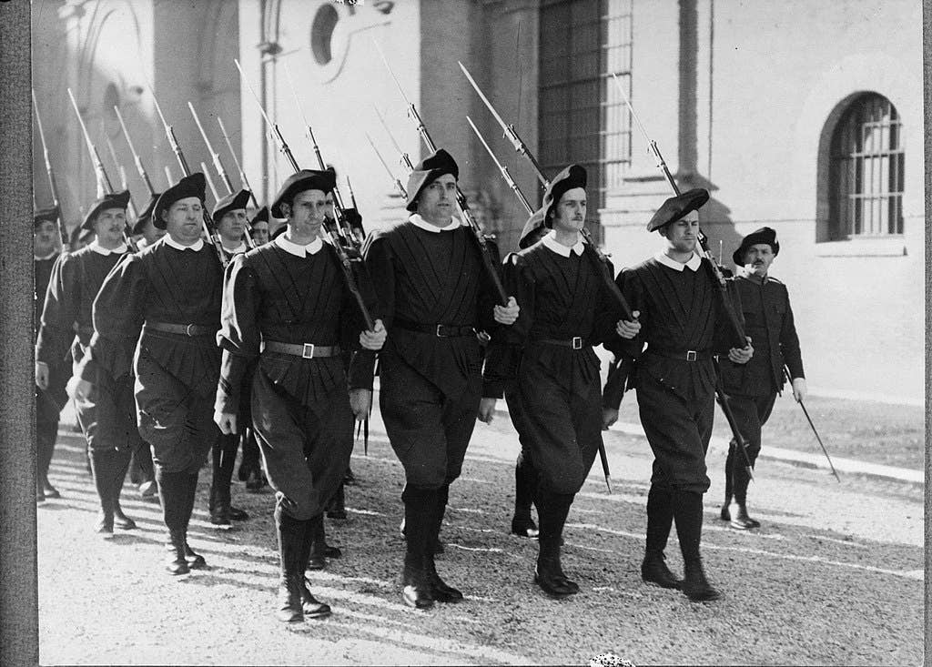 Marching in exercise uniform with rifles (1938). (Wikimedia Commons)