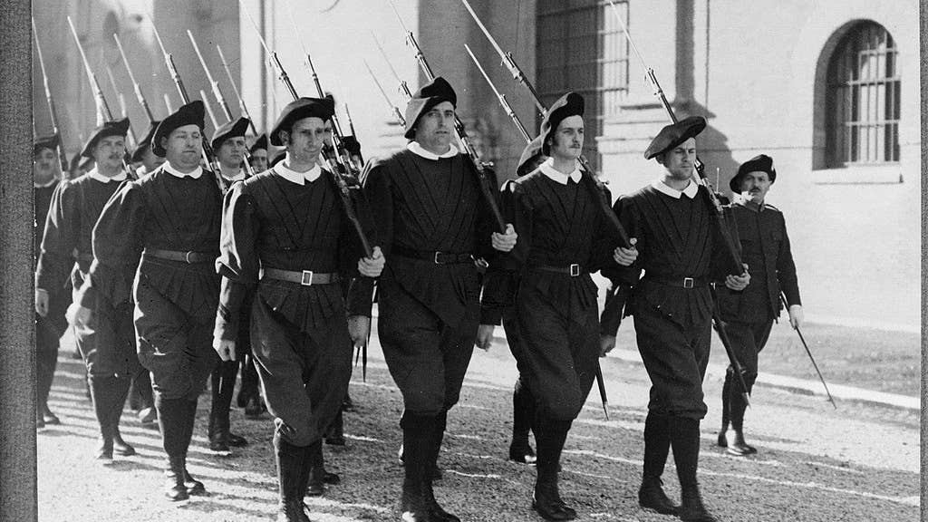 Marching in exercise uniform with rifles (1938). (Wikimedia Commons)