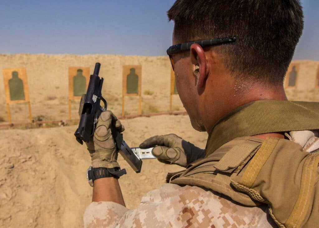 A US Marine reloads an M1911 MEUSOC .45-caliber pistol during an advanced marksmanship range, August 19, 2013. <br>US Marine Corps
