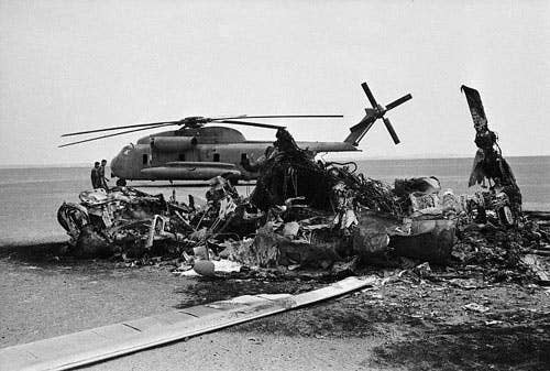 A helicopter in ashes during Operation Eagle Claw. Photo courtesy of Wikimedia Commons.