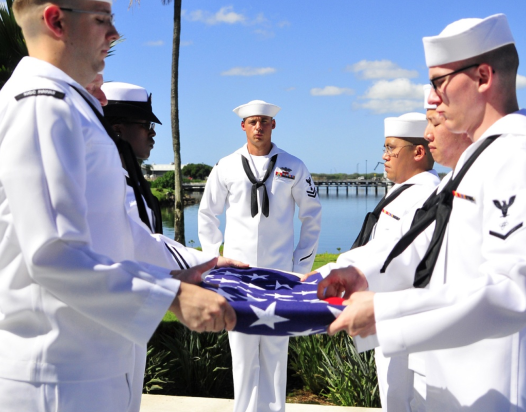 Members of the Joint Base Pearl Harbor-Hickam Honors and Ceremonies participate in a flag folding during an ash scattering ceremony at the USS Utah Memorial for Pearl Harbor survivor William Henderson. Henderson served aboard USS Helena (CL 50) during the 1941 Japanese attacks on Pearl Harbor. (U.S. Navy photo by Mass Communication Specialist 2nd Class Tiarra Fulgham/Released)