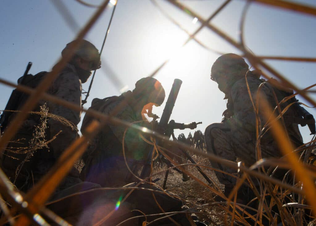 U.S. Marines with Kilo Company, 3d Battalion, 8th Marine Regiment, prepare to fire a 60mm mortar during a live-fire range as part of exercise Fuji Viper 21.2 at Combined Arms Training Center, Camp Fuji, Japan, Jan. 14, 2021. During this evolution of Fuji Viper, Marines honed their tactical skills, demonstrating that infantry formations can facilitate joint force multi-domain maneuver in support of naval operations. 3/8 is forward-deployed in the Indo-Pacific under 4th Marine Regiment, 3d Marine Division. (U.S. Marine Corps photo by Lance Cpl. Alexis Moradian)