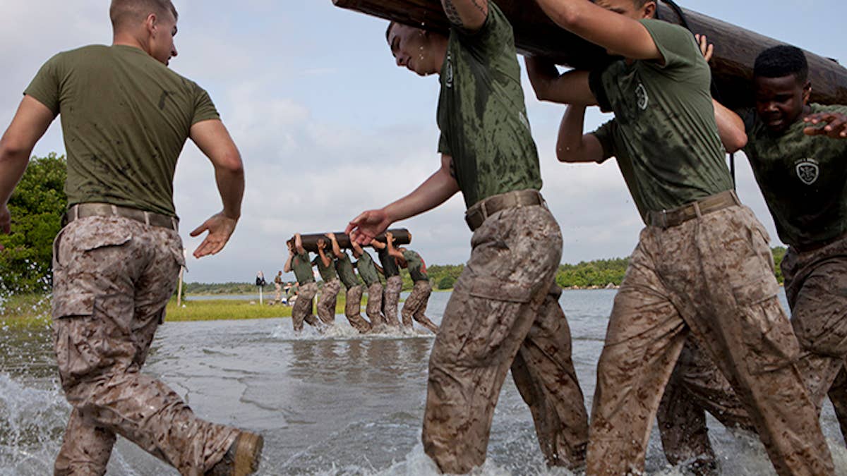 U.S. Marines with 10th Marine Regiment (10th Mar Reg), 2nd Marine Division (MARDIV), carry a log during the 10th Mar Reg King's Games field meet at Onslow Beach, Camp Lejeune, N.C., May 29, 2014. The field meet was held to boost morale and develop camaraderie within the unit through a physical competition. (U.S. Marine Corps photo by Lance Cpl. Kelly Timney, 2nd MARDIV, Combat Camera/Released)