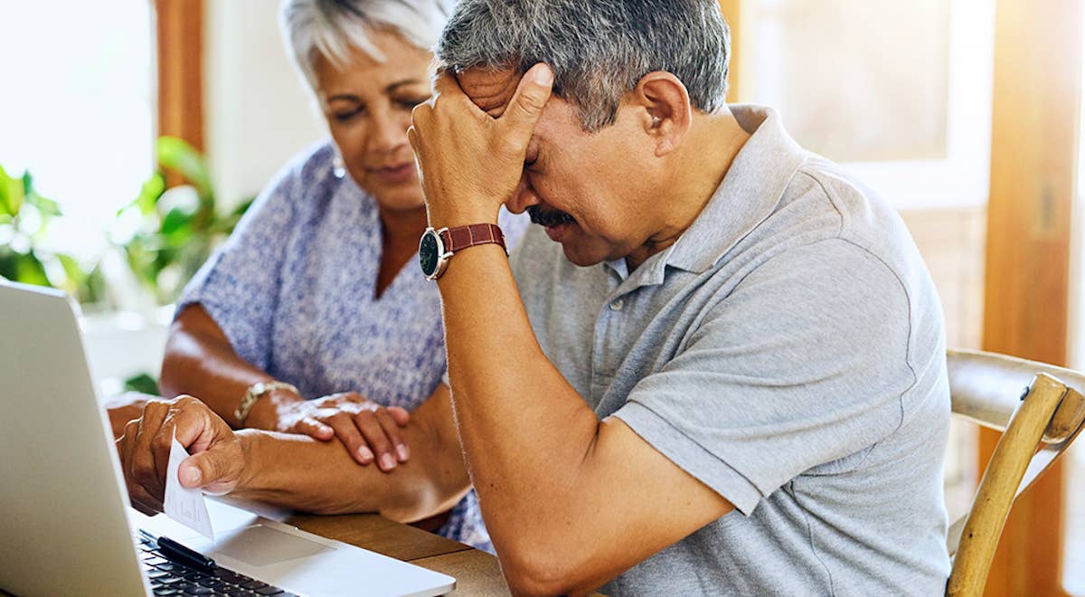 Shot of a mature couple looking stressed out while managing their paperwork together at home