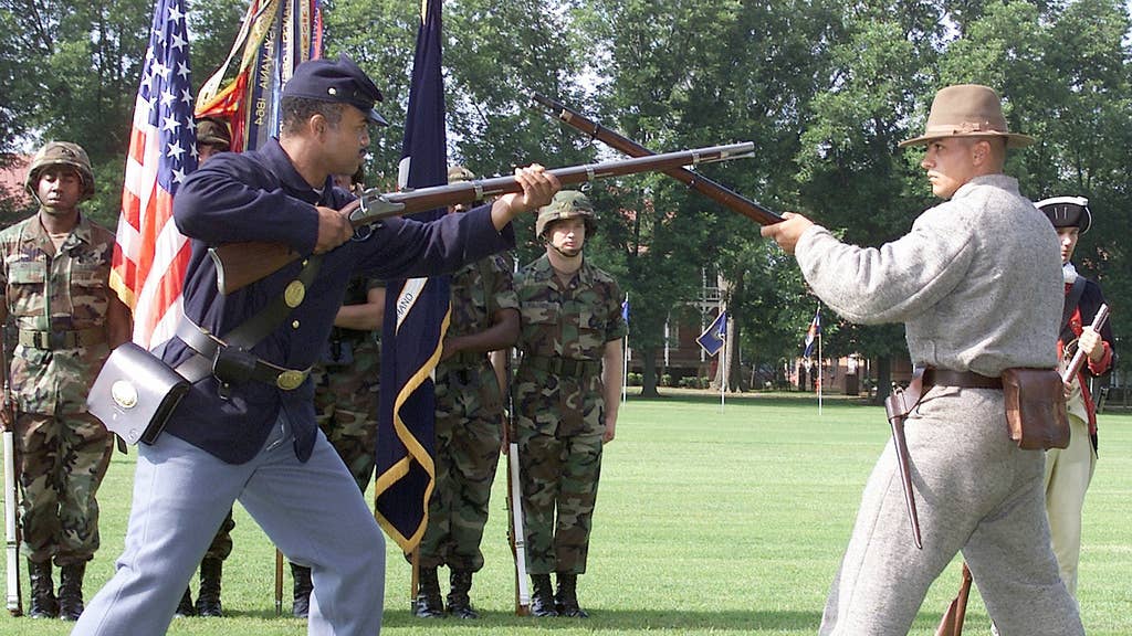 Dressed in the uniform of the Union Army and the Confederate Army, two Re-enactors, armed with musket rifles, perform a re-enactment of a standoff during the Civil War. A Living History Pageant was the center of the Army's 226th Birthday Celebration at Fort McPherson, GA.