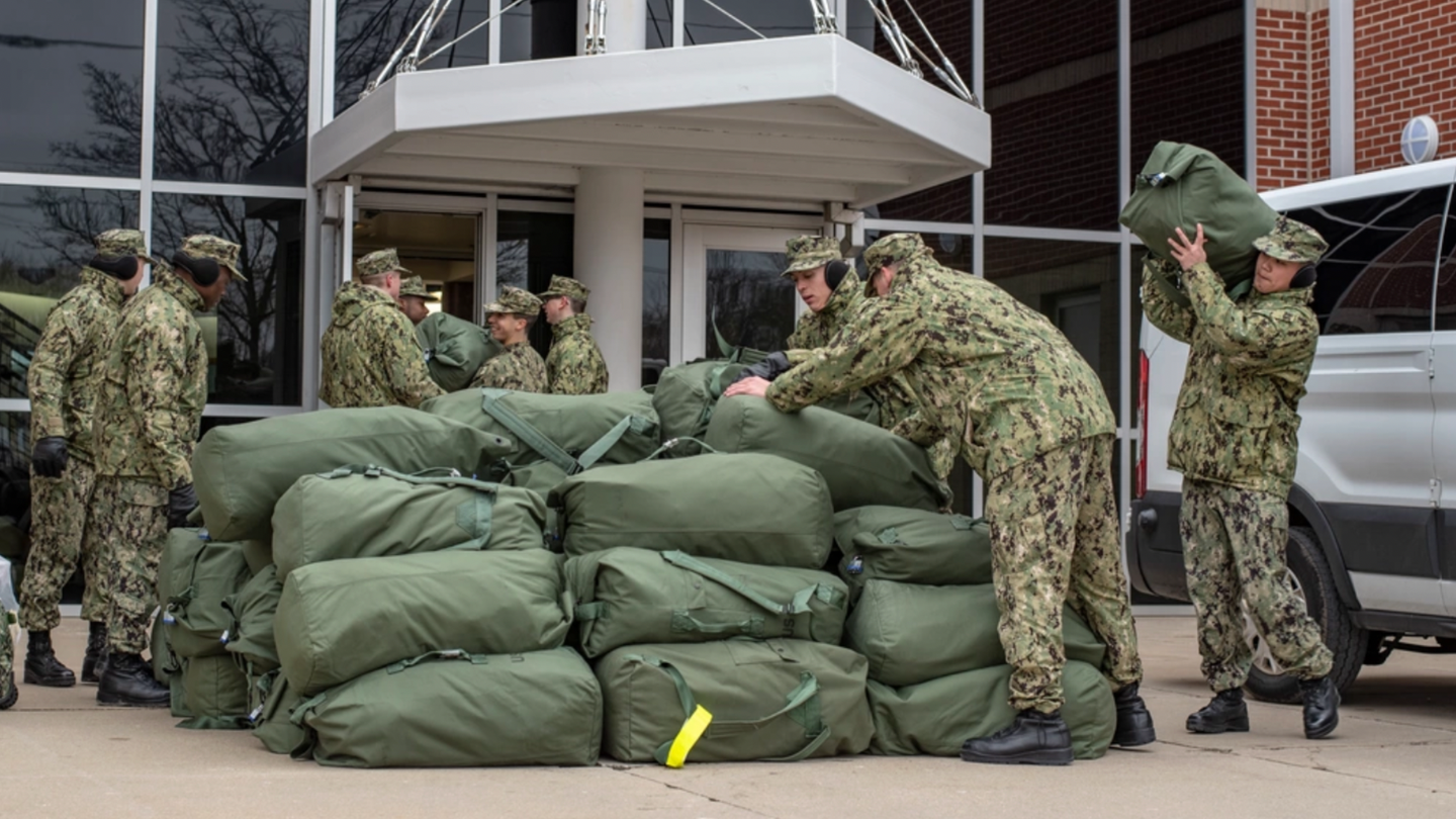 sailors stowing their stack of seabags