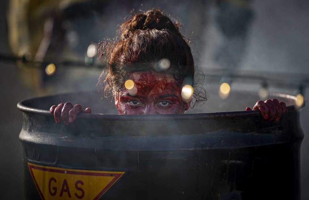 U.S. Marine Corps Lance Cpl. Melanie Macdonald, a Chemical, Biological, Radiological and Nuclear Defense Specialist, with 1st Marine Air Wing, poses as a zombie and hides, waiting to jump out at kids as they trick-or-treat, on Camp Foster, Okinawa, Japan, Oct. 31, 2020.