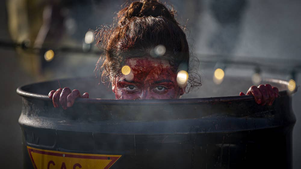 U.S. Marine Corps Lance Cpl. Melanie Macdonald, a Chemical, Biological, Radiological and Nuclear Defense Specialist, with 1st Marine Air Wing, poses as a zombie and hides, waiting to jump out at kids as they trick-or-treat, on Camp Foster, Okinawa, Japan, Oct. 31, 2020.