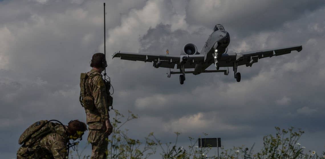 Two combat controllers with the 321st Special Tactics Squadron observe an A-10 Thunderbolt II landing on Jägala-Käravete Highway, Aug. 10, in Jägala, Estonia. A small force of eight Special Tactics combat controllers from the 321st STS surveyed the two-lane highway, deconflicted airspace and exercised command and control on the ground and in the air to land A-10s from Maryland Air National Guard's 104th Fighter Squadron on the highway. (U.S. Air Force photo by Senior Airman Ryan Conroy)