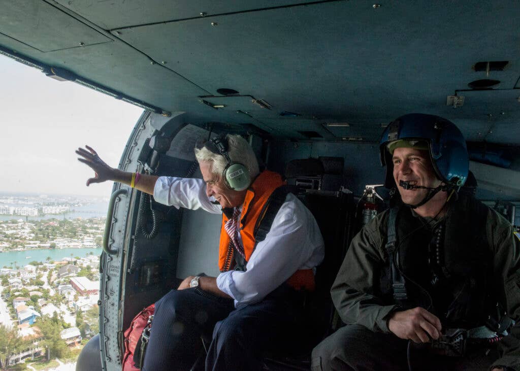 Congressman Charlie Crist, U.S. Representative for Florida's 13th District, waves to beachgoers Tuesday, May 30, 2017, alongside Petty Officer 3rd Class Justin Kuchar, crew member at Air Station Clearwater, during an aerial assessment of erosion along Pinellas County, Florida’s coast.  U.S. Coast Guard by Petty Officer 1st Class Michael De Nyse