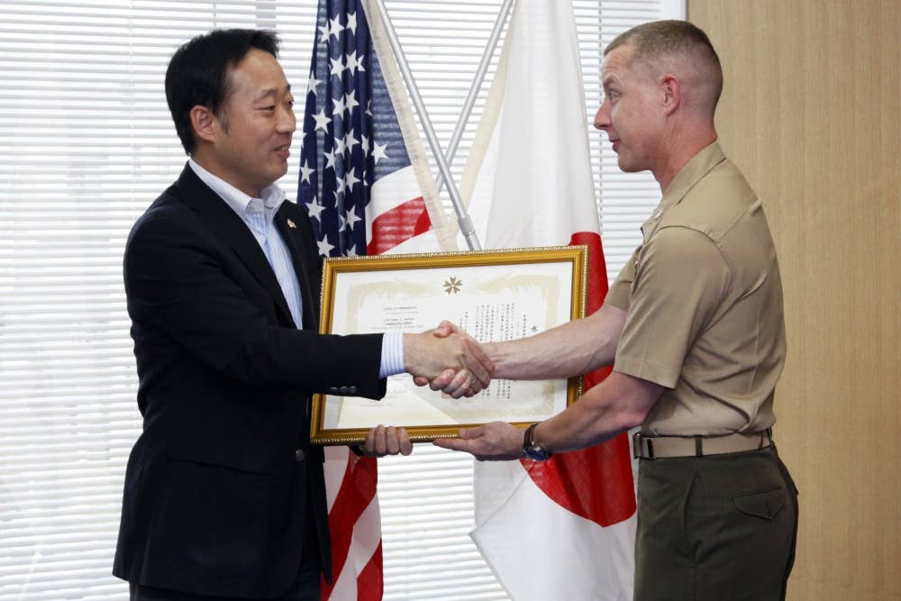 Yoshihiko Fukuda, Iwakuni city mayor, presents Col. James C. Stewart, station commanding officer, with a letter of appreciation at the Iwakuni cityhall, June 13, for the station’s contribution during Operation Tomodachi. Operation Tomodachi was the joint relief effort conducted by the U.S. and Japanese government to help the victims of the 9.0 magnitude earthquake and tsunami that shook northern Japan March 11.