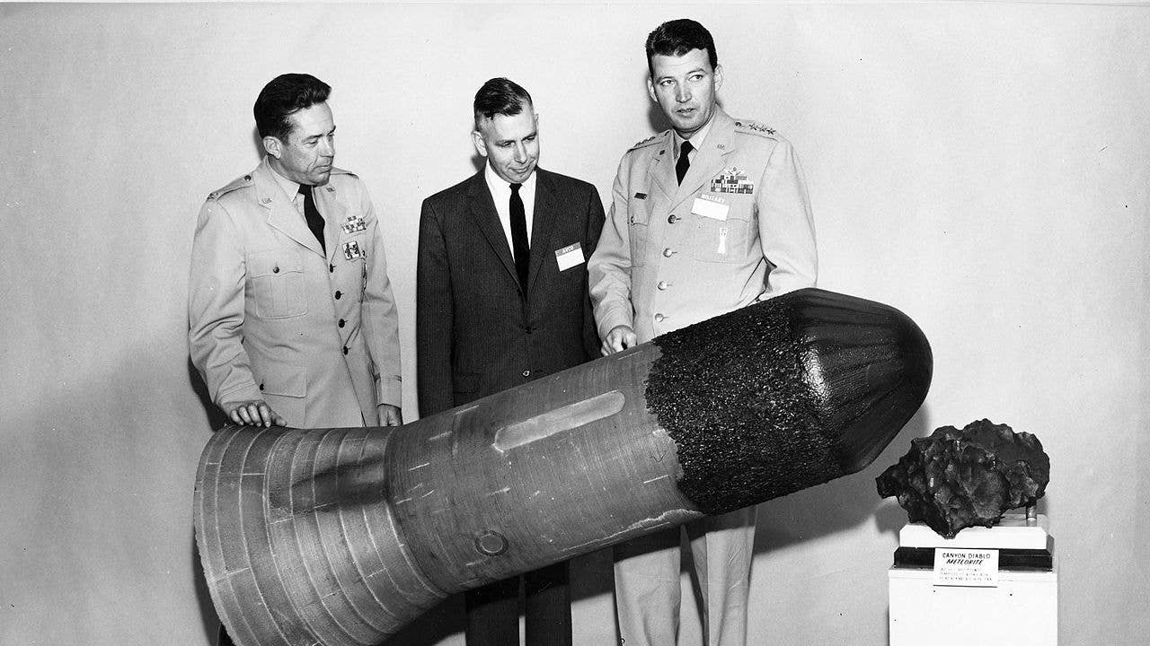 General Bernard A. Schriever (right) with members of Avco Cooperation (today: Textron, Inc) inspects an experimental missile warhead re-entry vehicle in 1959. Creating an effective nuclear-armed missile force was one of his main goals. ICBM Test Vehicle of U.S. Air Force Thor-Able Reentry Program. Recovered April 1959 after 5000 mile flight. (U.S. Air Force photo)
