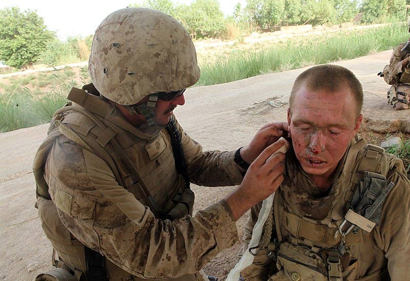 100501-M-7069A-018.MARJAH, Afghanistan (May 1, 2010) Hospital Corpsman 3rd Class Bradley Erickson, assigned to 1st Platoon, India Company, 3rd Battalion, 6th Marine Regiment, Regimental Combat Team 7, cleans facial wounds for Lance Cpl. Timothy Mixon after an improvised explosive device attack during a patrol. The unit is deployed supporting the International Security Assistance Force. (U.S. Marine Corps photo by Cpl. Michael J. Ayotte/Released).