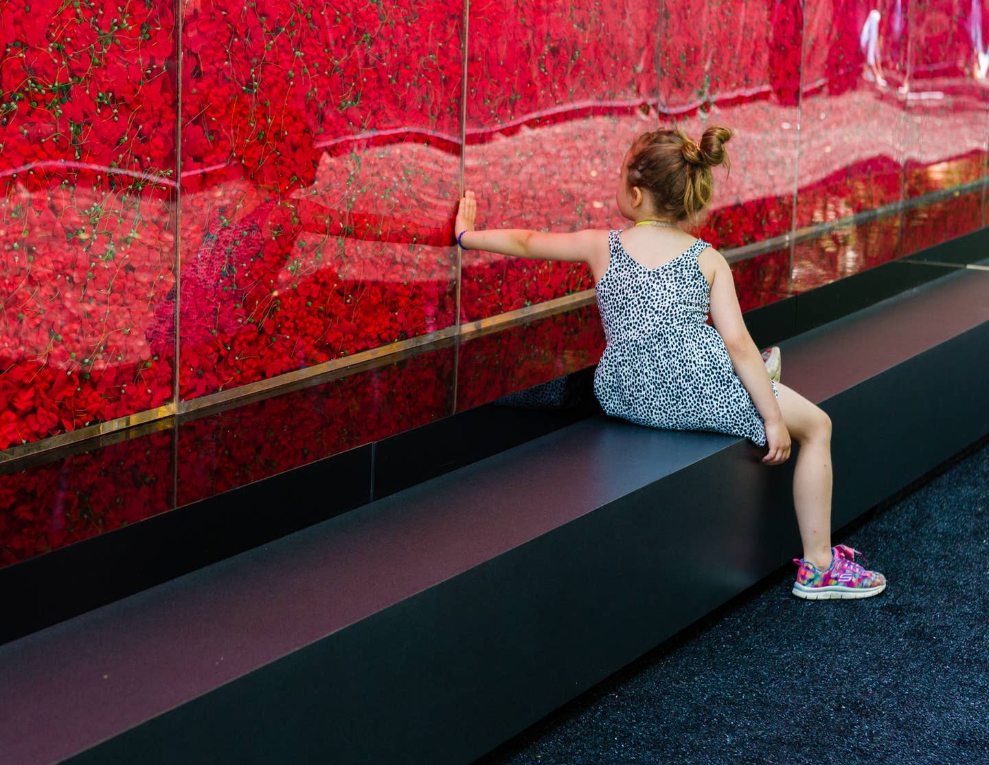 Girl visits The Poppy Memorial, a temporary memorial made by USAA consisting of more than 645,000 poppy flowers, with each flower honoring a fallen military servicemember since World War I, is seen at the National Mall on May 25, 2018 in Washington, D.C. (Photo by Rodney Choice/AP Images for USAA) Photo provided by USAA.