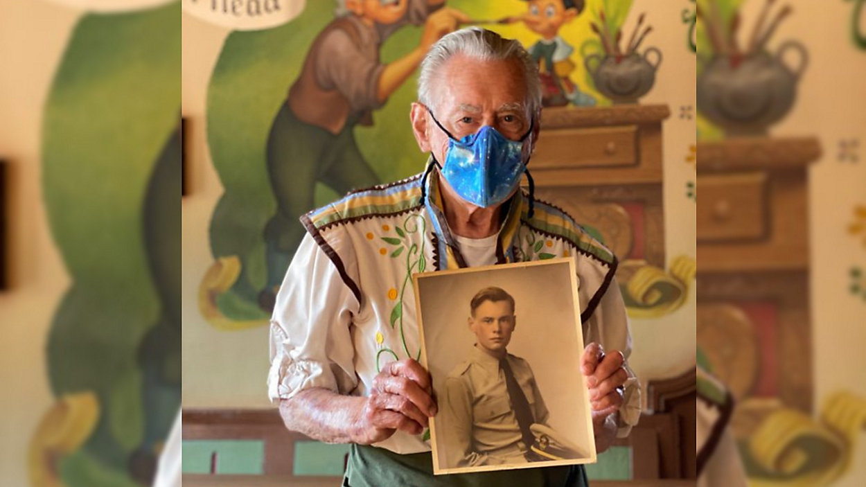 Alex Stromski, a Disney World cast member and U.S. Navy veteran, holds a 1950 photo of himself in uniform. (Disney)