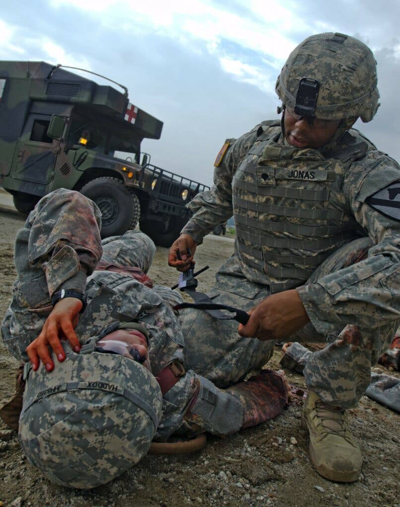 Spc. Leon Jonas, a 24 year old combat medic from Hanover, Maryland, who works at the combined troop aid station for the 1st Battalion, 9th Cavalry Regiment, 2nd Armored Brigade Combat Team, 1st Cavalry Division, applies a combat application tournique...&nbsp;<em>(Photo Credit: U.S. Army)</em>