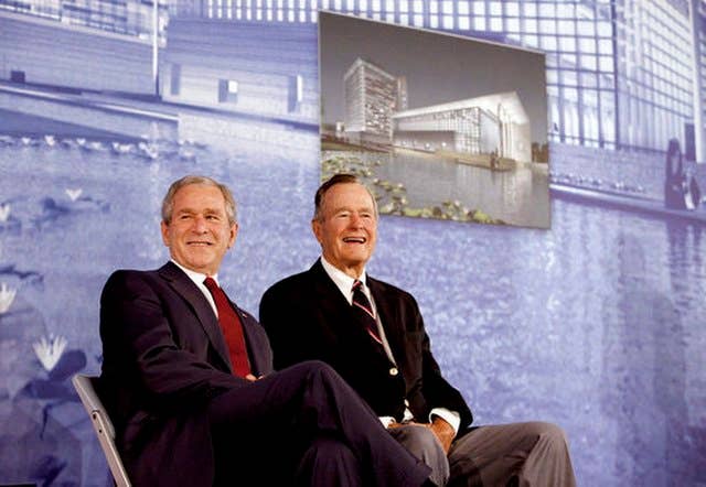 President George W. Bush and former President George H.W. Bush sit on stage at the U.S. Embassy in Beijing Friday, Aug. 8, 2008, during dedication ceremonies. Both are scheduled to attend opening ceremonies scheduled for later in the evening.<br>White House photo by Eric Draper.