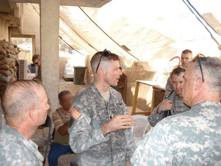 Key leader meeting at Combat Outpost (COP) Casino. Note the sweat-drenched uniform after removing body armor. Author Steve Miska (center), Colonel J.B. Burton (right with back turned), Major Scott Nelson (opposite Burton), and LTC Barry Niles, Iraqi Army Military Transition Team Chief (bottom left). Photo: Courtesy of Steve Miska