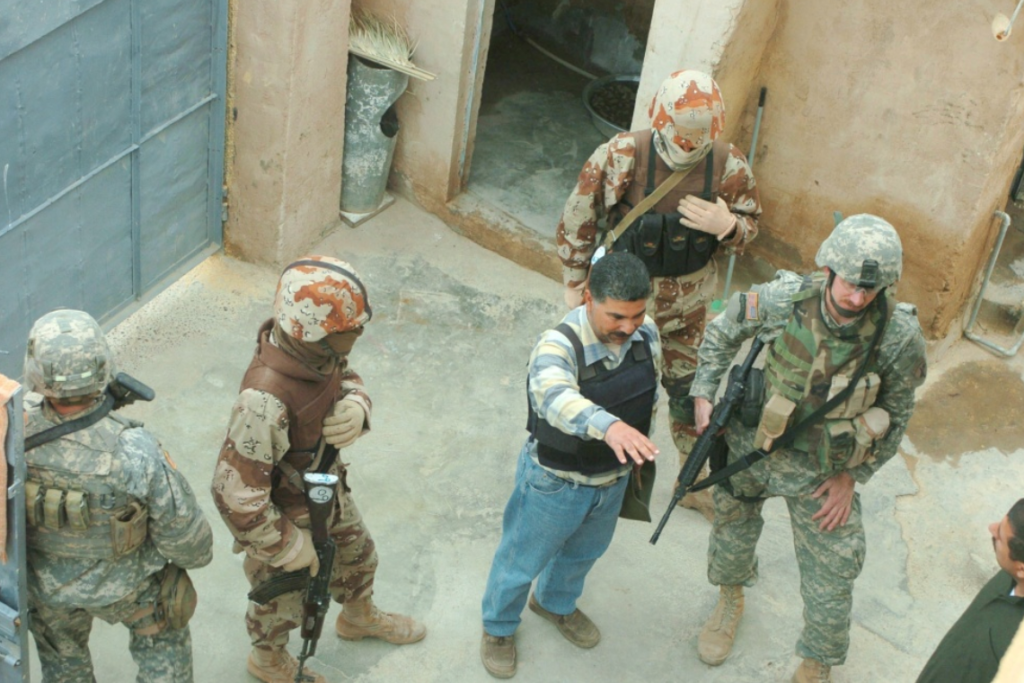 Troops from 2nd Squadron, 9th US Cavalry attached to the 3rd Brigade Combat Team, 101st Airborne Division and Iraqi Army soldiers use an interpreter to talk to the resident of a house before they search it in Ad Dawr, Iraq.