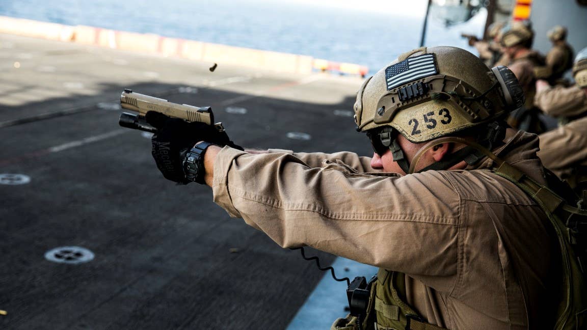 ARABIAN GULF (Oct. 5, 2015) U.S. Marine Cpl. Alex Daigle fires at his target with an M45 1911 A1 pistol during a deck shoot aboard the amphibious assault ship USS Essex (LHD 2). Daigle is a member of the 15th Marine Expeditionary Unit’s Maritime Raid Force. During the shoot, the Marines executed shuttle runs before firing to practice shooting while their bodies were fatigued. The 15th MEU, embarked aboard the ships of the Essex Amphibious Ready Group, is deployed to maintain regional security in the U.S. 5th Fleet area of operations. (U.S. Marine Corps photo by Cpl. Anna Albrecht/Released)