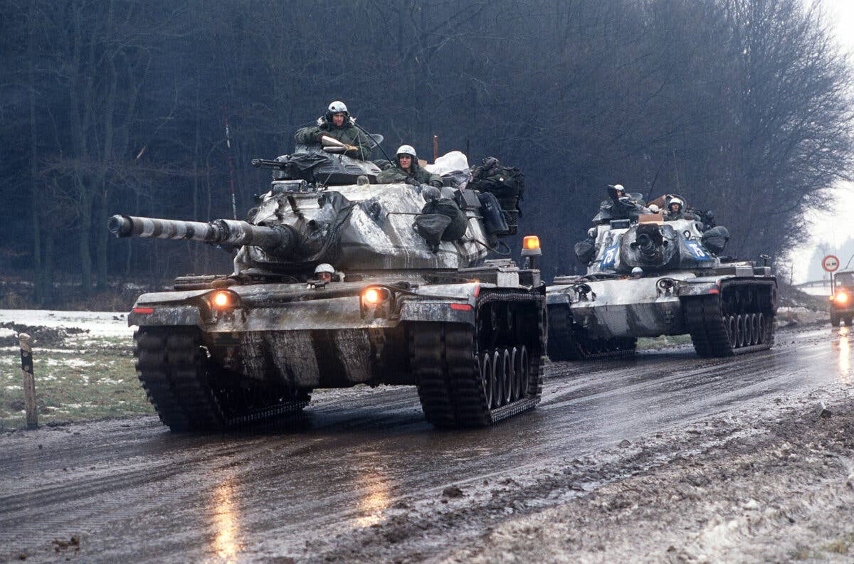 Two M-60A3 main battle tanks move along a road during Central Guardian, a phase of Exercise Reforger '85.