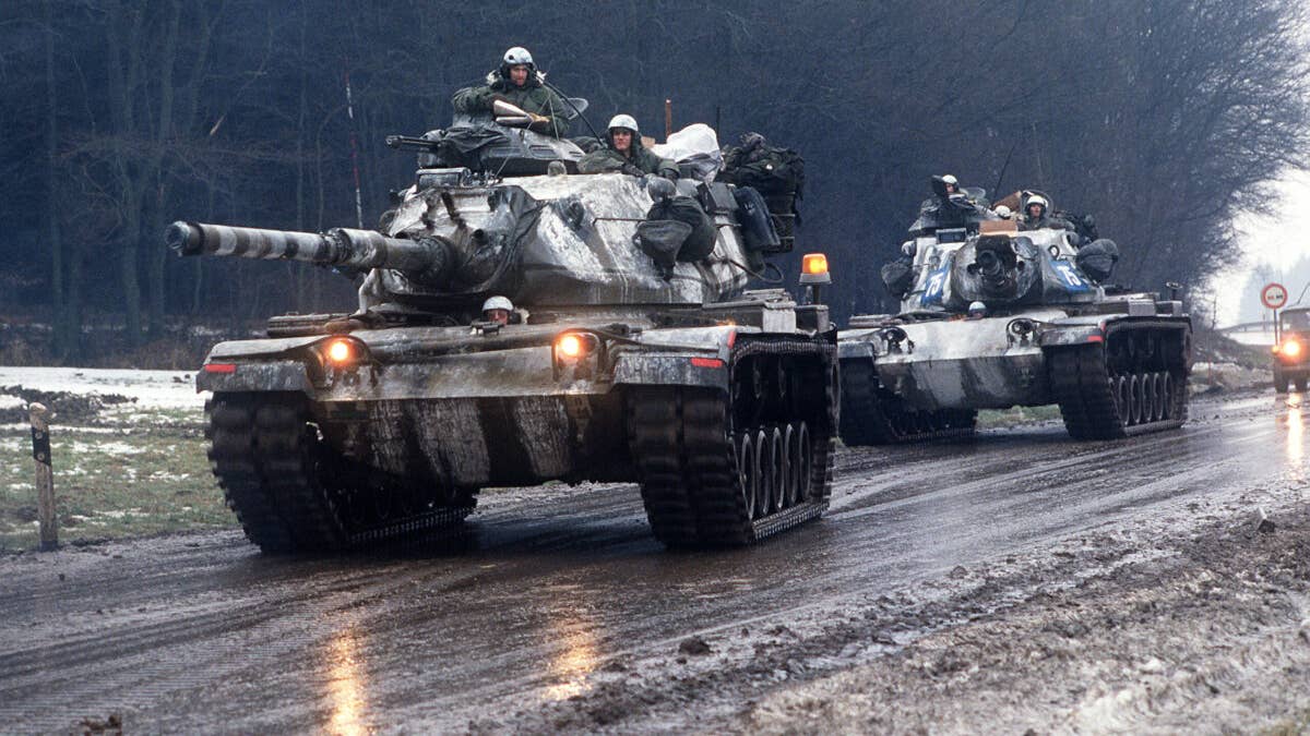 Two M-60A3 main battle tanks move along a road during Central Guardian, a phase of Exercise Reforger '85.