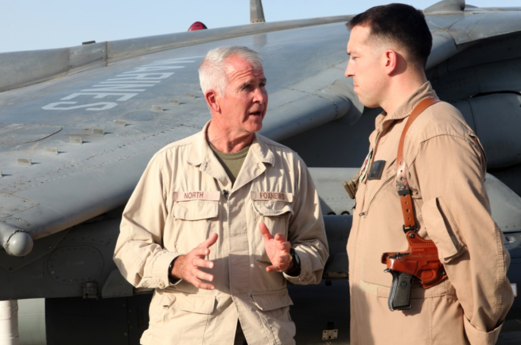 Retired U.S. Marine Lt. Col. Oliver North, Fox News reporter, interviews Marine Capt. Kevin T. Smalley, AV-8B Harrier pilot, Marine Attack Squadron (VMA) 211, Marine Aircraft Group 13, 3rd Marine Aircraft Wing (Forward) at Camp Bastion, Helmand province, Afghanistan, Oct. 12, 2012. North was visiting Marines and conducting interviews about the attack on Sept. 14, 2012.