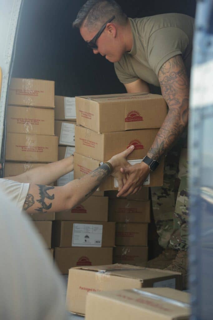 U.S. Army Master Sgt. Krystle McGrath, assigned to the 1st Armored Division (AD) CAB, loads food on a S-61 Sikorsky in San Juan, Puerto Rico, Oct. 11, 2017. The 1AD provided aviation assets to assist emergency services, the territory of Puerto Rico and federal agencies responding to the hurricane relief effort. (U.S. Army photo by Pfc. Kyara Aguilar)