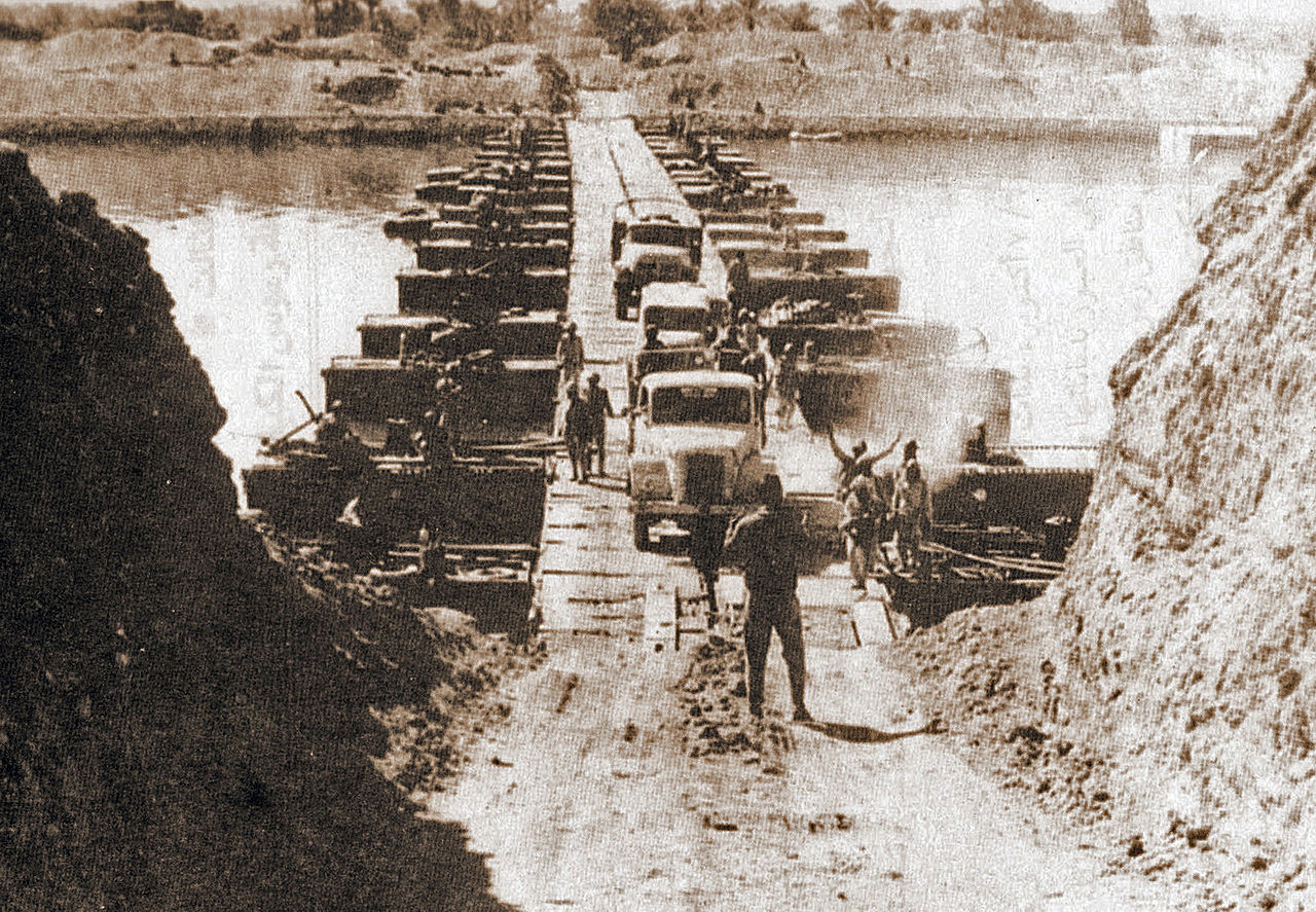 Egyptian military trucks cross a bridge laid over the Suez Canal on October 7, 1973, during the Yom Kippur War/October War. (Wikimedia Commons)