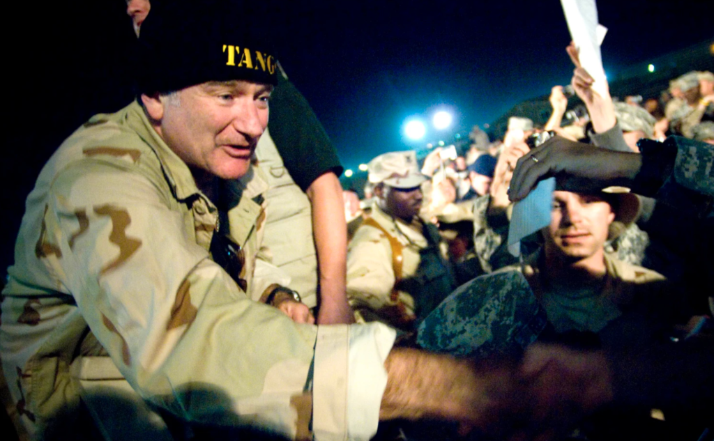 <em>Comedian Robin Williams greets troops during a USO Chairman’s Holiday Tour stop at Camp Arifjan, Kuwait, on Dec. 17, 2007. Photo by Chad J. McNeeley/Courtesy of the Department of Defense</em>
