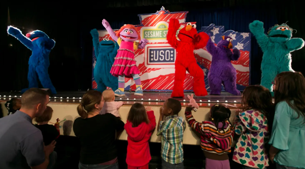 <em>Kids watch the 2012 Sesame Street/USO Experience for Military Families at Scott Air Force Base, Illinois. USO photo by Fred Greaves</em>