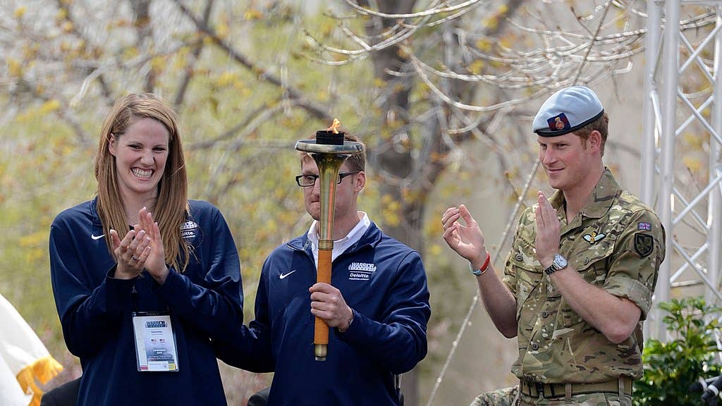 U.S. Olympic swimmer Missy Franklin, left, Paralympian gold medal winner Navy Lt. Bradley Snyder, center, and Prince Harry prepare to light the official torch to begin the 2013 Warrior Games at the U.S. Olympic Training Center in Colorado Springs, Colo., on May 11, 2013.  DoD photo by E. J. Hersom, U.S. Navy.  (Released)